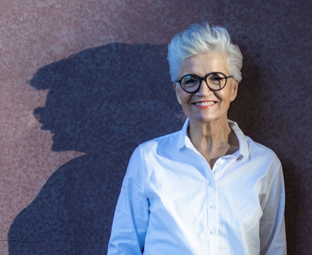 Greta Silver vor einer Wand. Hinter ihr ist ihr Schatten zu sehen