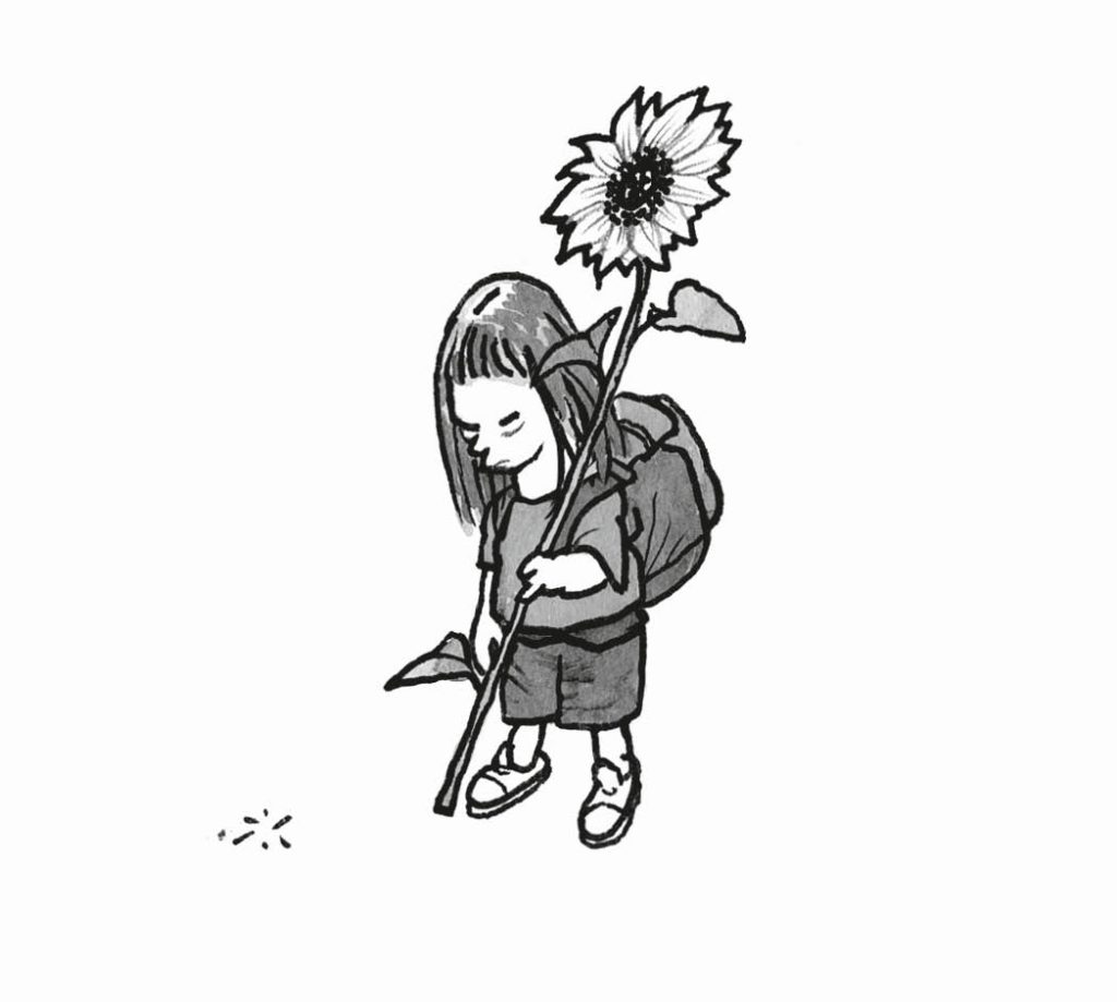 Eine Sch&uuml;lerin mit einer Sonnenblume in der Hand.
