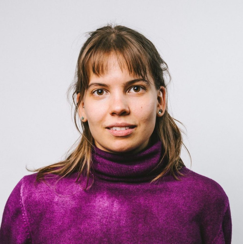 Clara Porák schaut in die Kamera. Sie trägt einen violetten Pullover.
