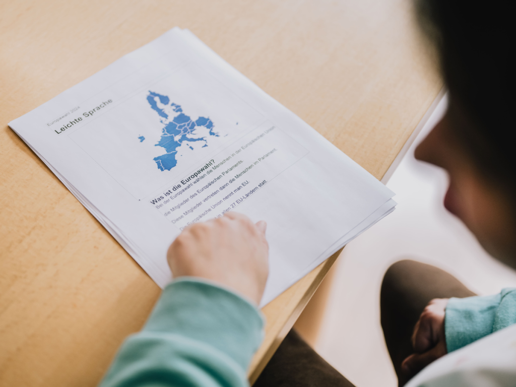 Auf einem Tisch liegen Zettel. Darauf steht "Was ist die Europawahl".
