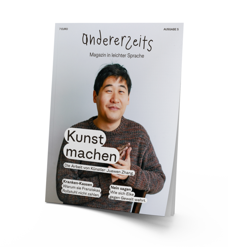 Auf dem Magazin ist der Künstler Juewen Zhang. Er hat schwarze Haare,trägt einen Strickpulli und lächelt in die Kamera. Sein Hände sind voller Kohle.